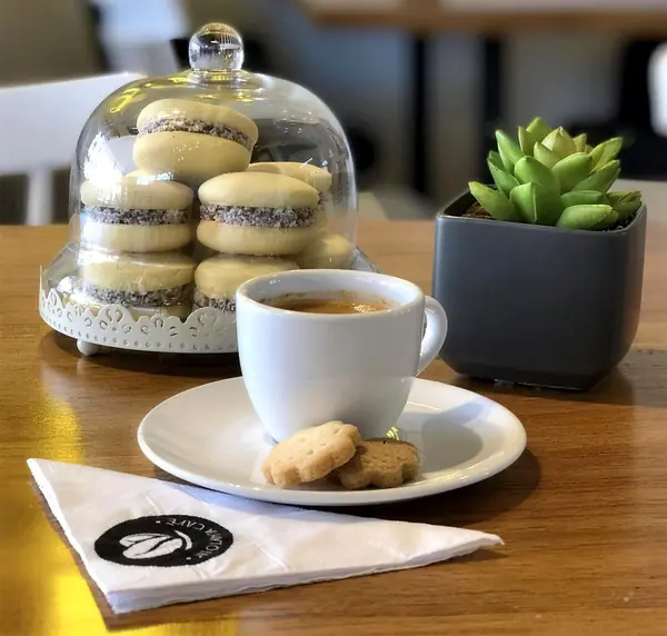 Alfajores bajo una campana de vidrio y un espresso con galletitas