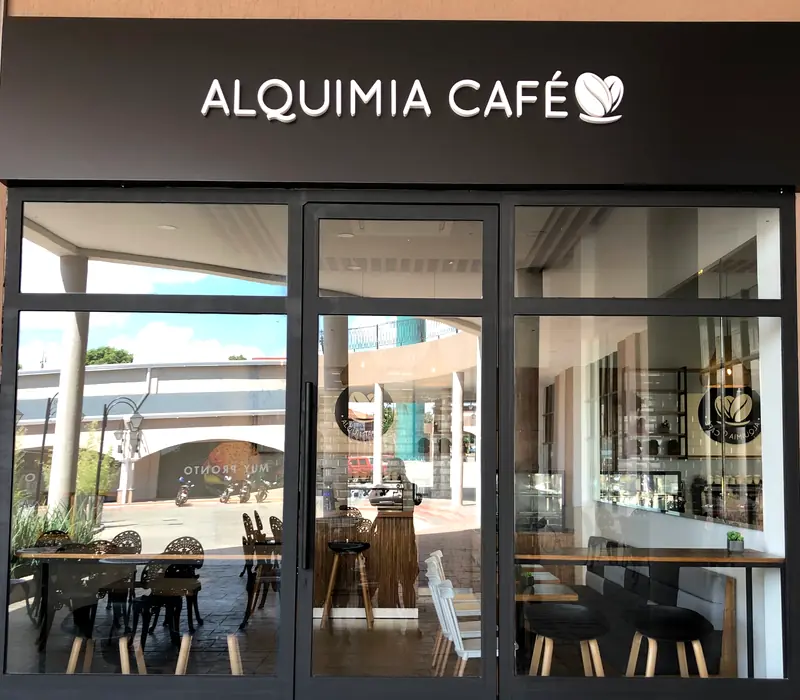 La entrada de Alquimia Café con su letrero negro y letras blancas