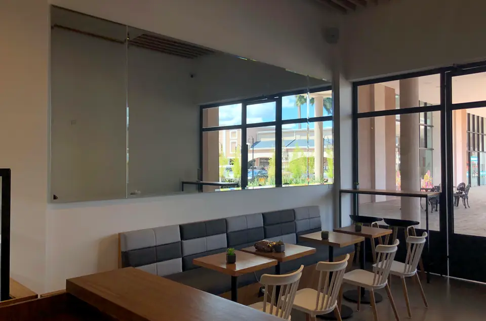 El salón de Alquimia con mesas de madera, bancos tapizados y ventanales